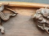 carvings of a dragon and a dragon head on a wooden plaque