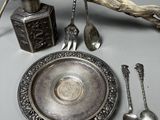 un plateau en argent avec des cuillères et un repose-cuillères posé sur une table