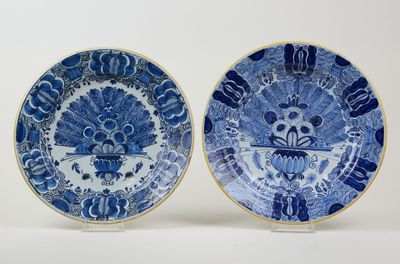 two blue and white plates with designs of birds and flowers