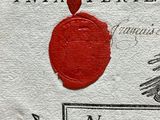 a red wax seal on a piece of paper with a ship in the background