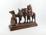 an image of a figurine of three people riding on camels