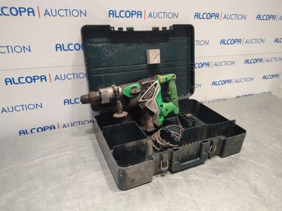 a green drill in a black case on a white surface
