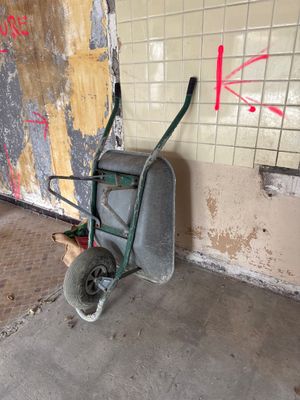 une brouette dans un coin d'une pièce dont le mur est recouvert de graffitis