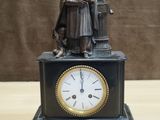 a statue of a man with a clock on a table