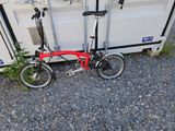 un vélo rouge garé à côté d'un conteneur blanc