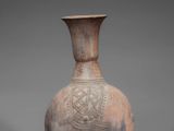 an old vase with a wooden stand on a gray background