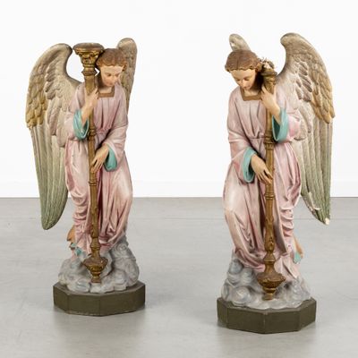 two figurines of angels are sitting on a pedestal