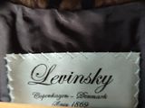 a label on a black dress with a brown fur collar