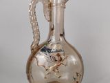 un vase en verre orné d'un dragon, posé sur une table