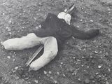 a black and white photo of a dead person laying on the ground