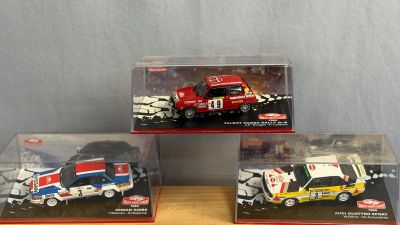trois petites voitures dans une vitrine posée sur une table