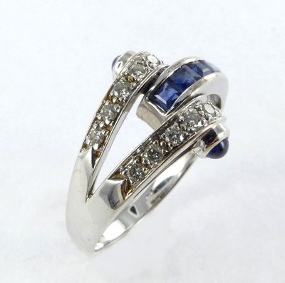 gros plan d'une bague en diamant et saphir sur une surface blanche