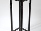 une table noire avec un plateau en bois sur fond blanc