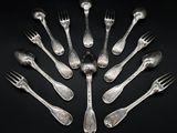 silver plated forks arranged in a circle on a black background