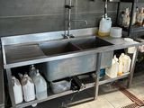 a kitchen with a sink and a lot of bottles on the counter