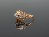 a close up of a gold ring with diamonds on a reflective surface