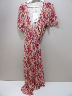 une robe rose à fleurs suspendue à un cintre accroché au mur