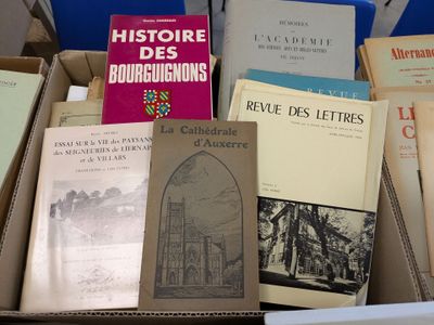 several books are stacked on top of each other in a box