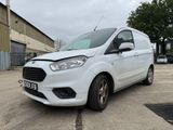 une camionnette blanche garée sur un parking à côté d'un bâtiment