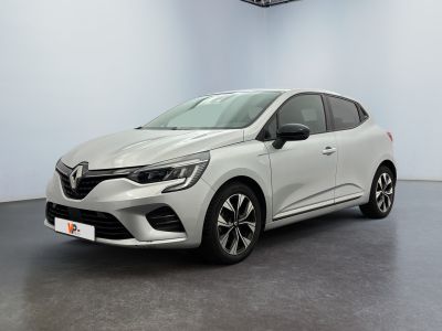 Une voiture blanche est garée dans une pièce au sol noir.