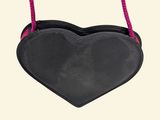 black heart shaped purse hanging from a rope on a white background