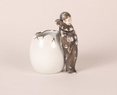 a figurine of a man standing next to an egg