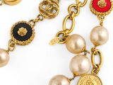 a close up of a necklace with pearls and gold coins