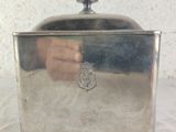 a small silver container with a lid on a table