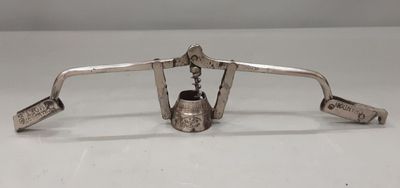 an antique silver plated bell with a bell hanging from it ' s side