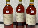 trois bouteilles de vin sont alignées sur une table