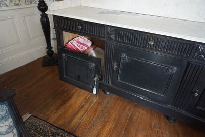un meuble noir avec un plateau en marbre, placé dans un coin de la pièce