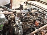 a man standing next to an old engine in the dirt
