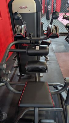 gym equipment in a gym with red walls and black flooring