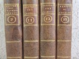 a set of four old books sitting on top of a table