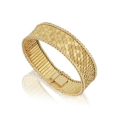 gros plan d'un bracelet en or sur fond blanc