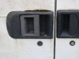 two black door handles on the side of a white van