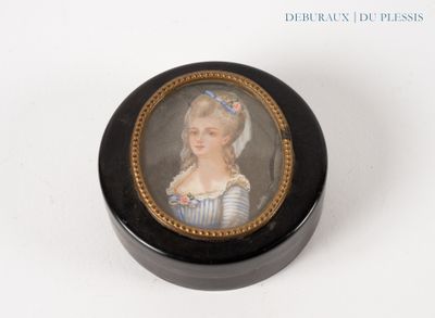 une petite boîte noire sur laquelle figure la photo d'une femme