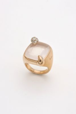 a close up of a gold ring with a white stone and a diamond