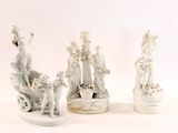 trois figurines blanches représentant des personnes et des animaux sur un fond blanc