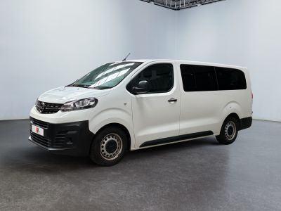 La camionnette blanche est garée dans une pièce blanche au plafond noir.