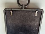 a black suitcase hanging on the wall with a ring on it