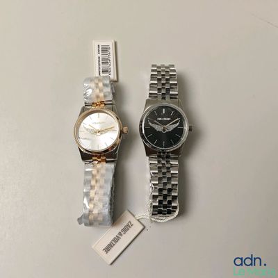 Deux montres sont posées l'une à côté de l'autre sur une table.