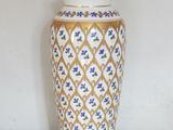 a white and gold vase with blue flowers on it