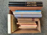 de nombreux livres dans une boîte en carton posée sur le sol