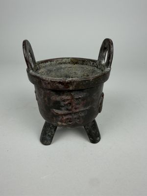 Brûle-parfum en bronze tripode à deux anses à décor de carac…
