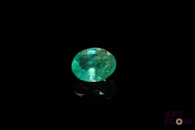 un gros plan d'une émeraude verte sur une surface noire