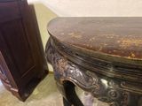 a small table with a wooden top and a cabinet in the background