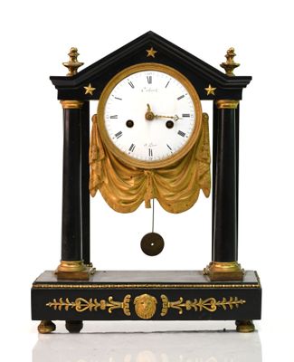 une horloge noire et or posée sur une table