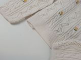 a close up of a white sweater with yellow flowers on it