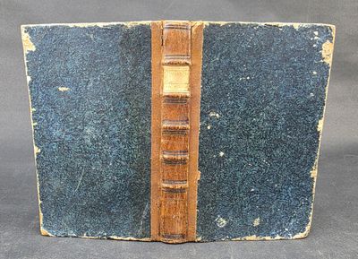 an old book with a wooden cover and a bookmark on it